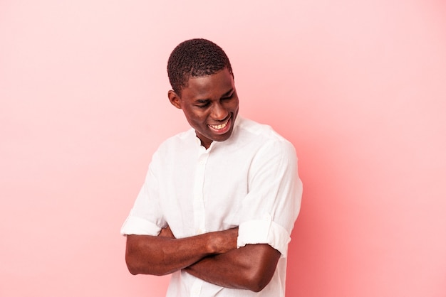 Молодой афро-американский мужчина, изолированные на розовом фоне, смеясь и весело.