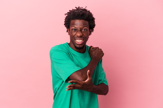 Young african american man isolated on pink background massaging elbow, suffering after a bad movement.