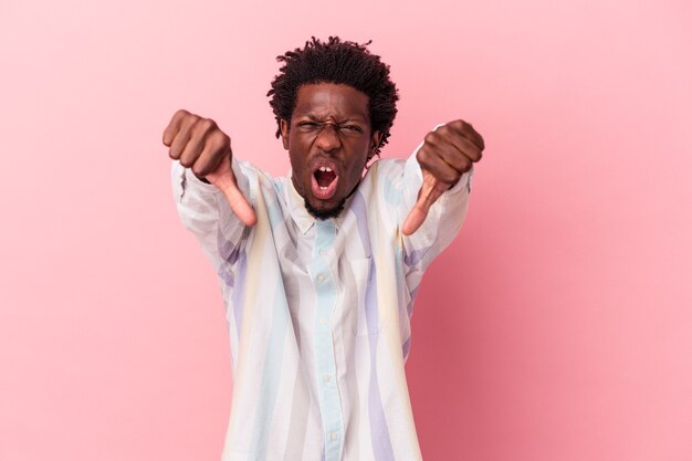 Young african american man isolated on pink background showing thumb down and expressing dislike.