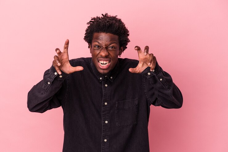 Photo young african american man isolated on pink background upset screaming with tense hands.