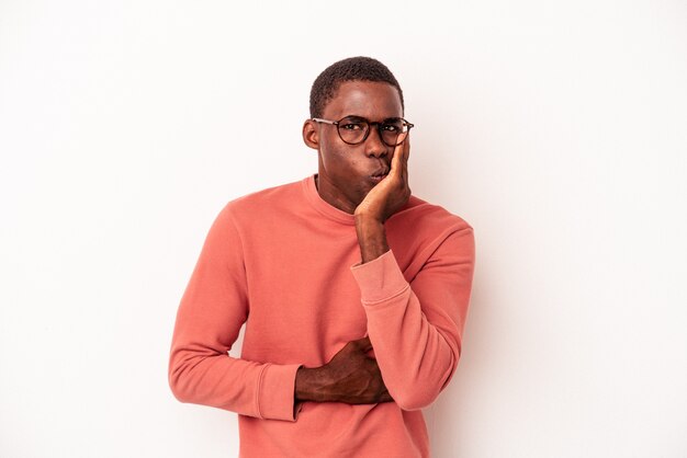 Young African American man isolated on white background blows cheeks, has tired expression. Facial expression concept.