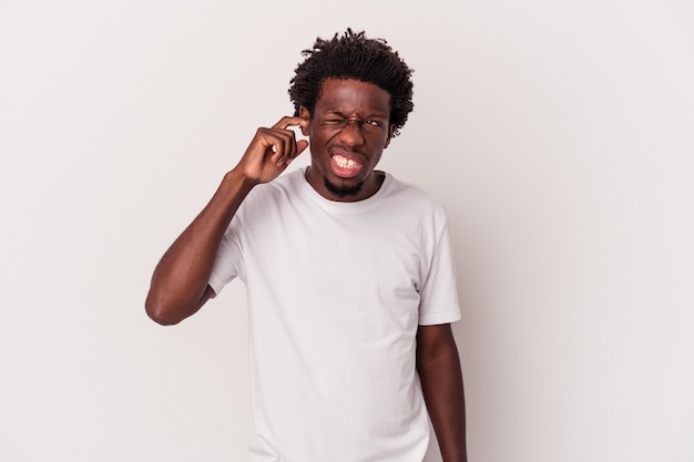 Young african american man isolated on white background  covering ears with fingers, stressed and desperate by a loudly ambient.