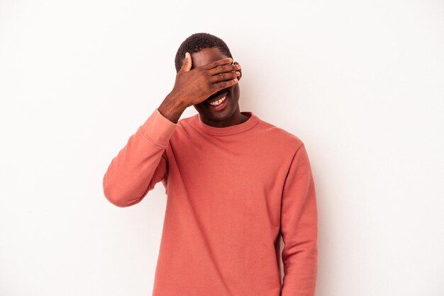 Young African American man isolated on white background covers eyes with hands smiles broadly waiting for a surprise