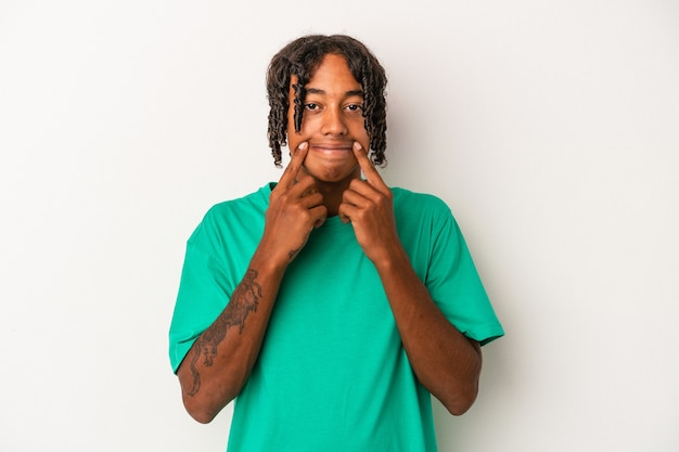 Young african american man isolated on white background doubting between two options.