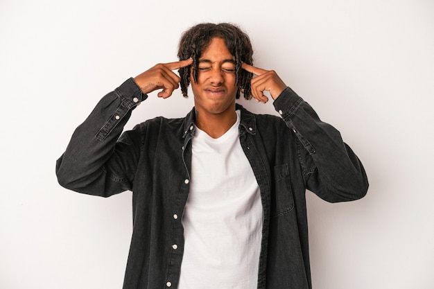 Young african american man isolated on white background focused on a task, keeping forefingers pointing head.