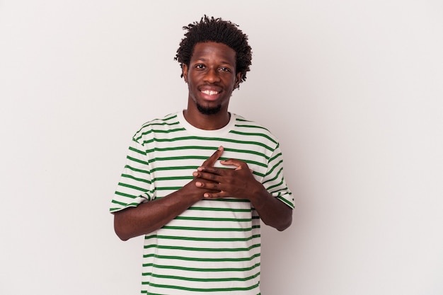 Young african american man isolated on white background  has friendly expression, pressing palm to chest. Love concept.