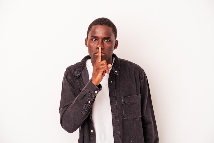 Photo young african american man isolated on white background keeping a secret or asking for silence