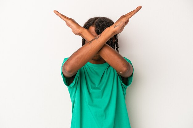 Young african american man isolated on white background keeping two arms crossed, denial concept.