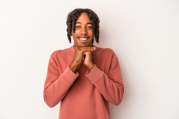 Young african american man isolated on white background praying for luck, amazed and opening mouth looking to front.