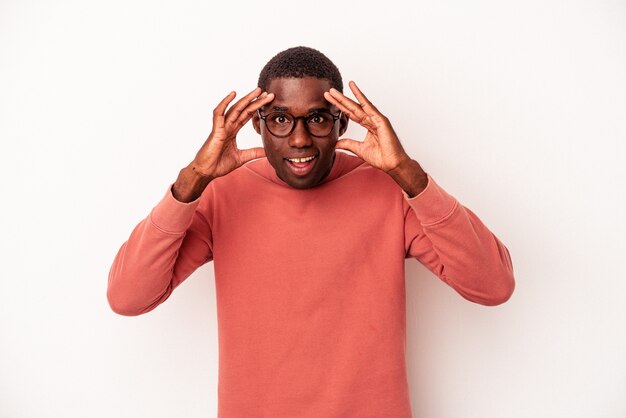 Young African American man isolated on white background receiving a pleasant surprise, excited and raising hands.