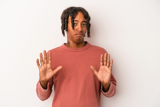 Young african american man isolated on white background rejecting someone showing a gesture of disgust.