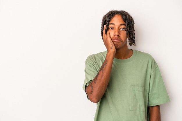 Young african american man isolated on white background who feels sad and pensive, looking at copy space.