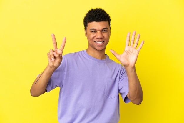 Young African American man isolated on yellow background counting seven with fingers