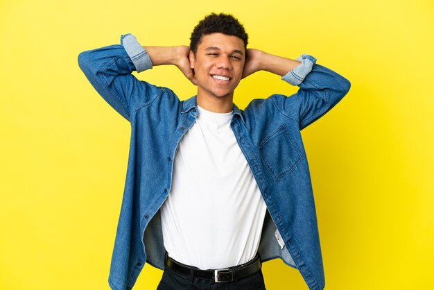 Young African American man isolated on yellow background laughing