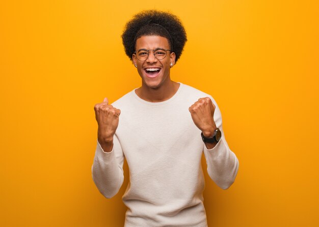 Photo young african american man over an orange wall surprised and shocked