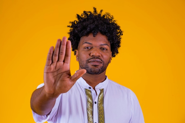 Young African American man shown hand on sign for them to stop with racial prejudice