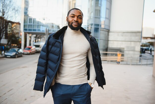 Young african-american man in stylish clothes posing outdoors