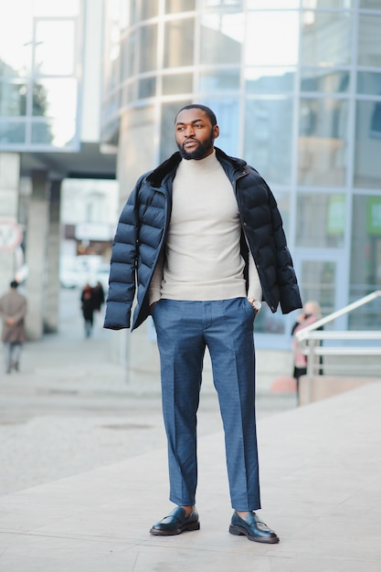 Young african-american man in stylish clothes posing outdoors