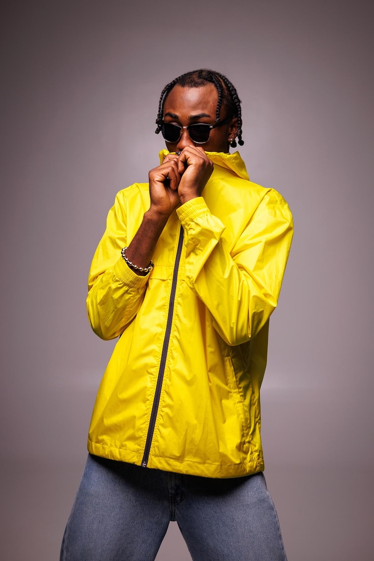 Photo young african american man in sunglasses wearing bright yellow windbreaker jacket isolated on grey