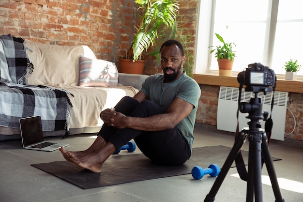 フィットネスの自宅オンラインコースで教える若いアフリカ系アメリカ人の男