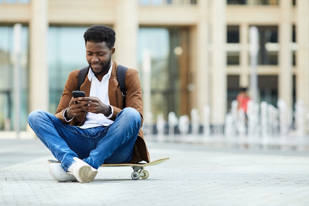 Young African-American Man Texting in City Square