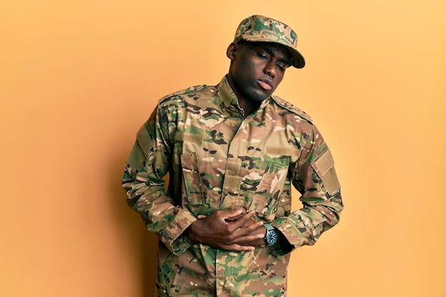 Young african american man wearing army uniform with hand on stomach because indigestion, painful illness feeling unwell. ache concept.