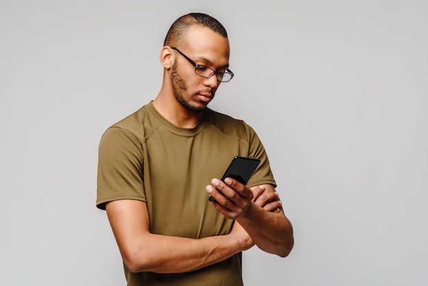  a young african american man wearing glasses holding cell phone