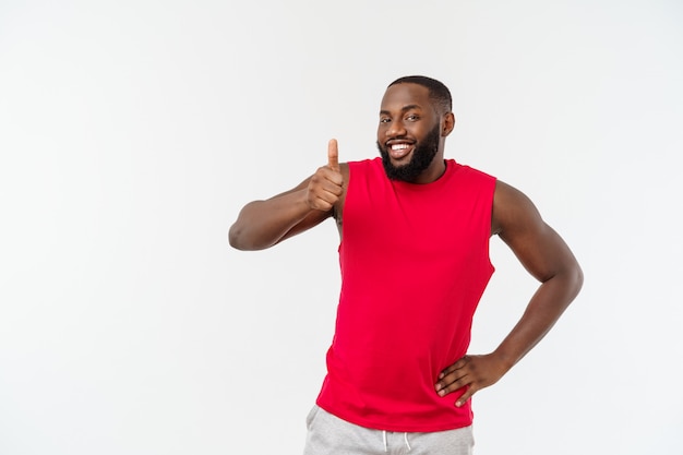 Young african american man wearing sport wear smiling with happy face looking with thumb up.