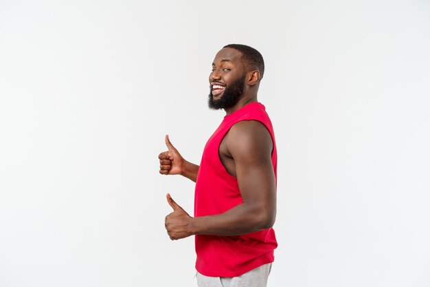 Носка спорта молодого Афро-американского человека нося усмехаясь при счастливое лицо смотря с большим пальцем руки вверх.