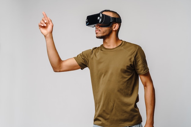 Photo young african american man wearing vr virtual reality headset over grey wall