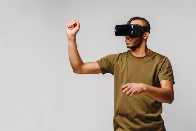 Photo young african american man wearing vr virtual reality headset over grey wall