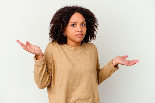 Young african american mixed race woman isolated doubting and shrugging shoulders in questioning gesture.