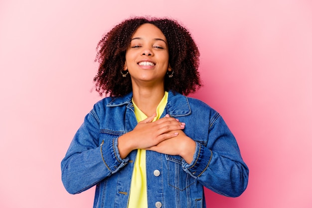 Young african american mixed race woman isolated laughing keeping hands on heart, concept of happiness.