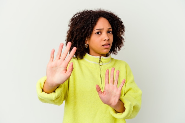 Giovane donna afroamericana di razza mista isolata rifiutando qualcuno che mostra un gesto di disgusto.