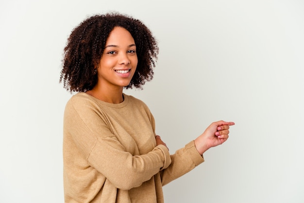 Young african american mixed race woman isolated smiling cheerfully pointing with forefinger away.