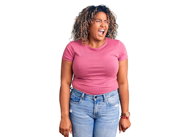Молодая афроамериканка плюс размер женщина в повседневной одежде злая и безумная, кричащая расстроенная и яростная, кричащая с гневом, яростью и агрессивной концепцией