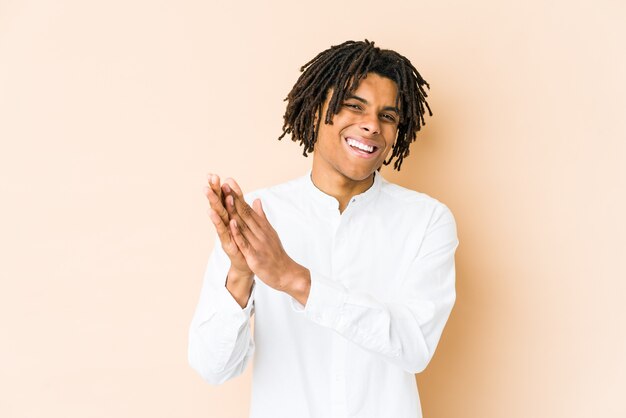 Young african american rasta man feeling energetic and comfortable, rubbing hands confident.