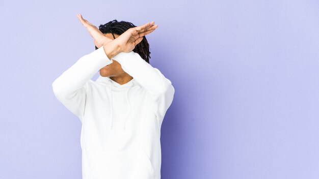 Young african american rasta man keeping two arms crossed, denial concept.