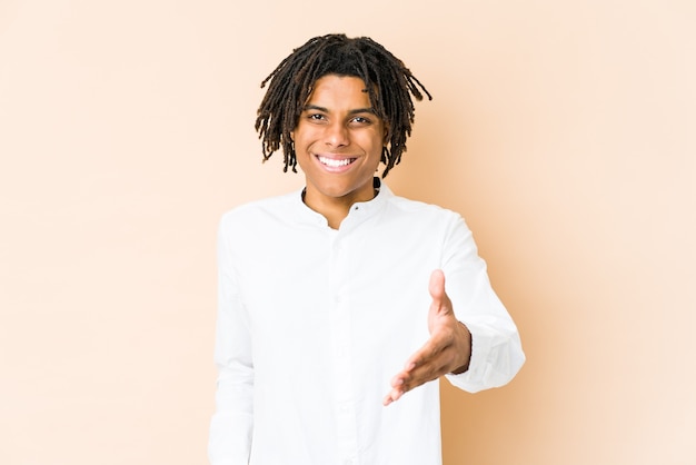 Young african american rasta man stretching hand at front in greeting gesture.