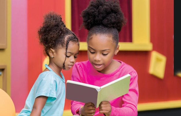 Young African American sisters sitting reading a book