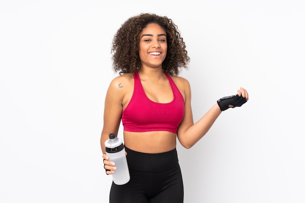 Young African American sport woman isolated on white with sports water bottle