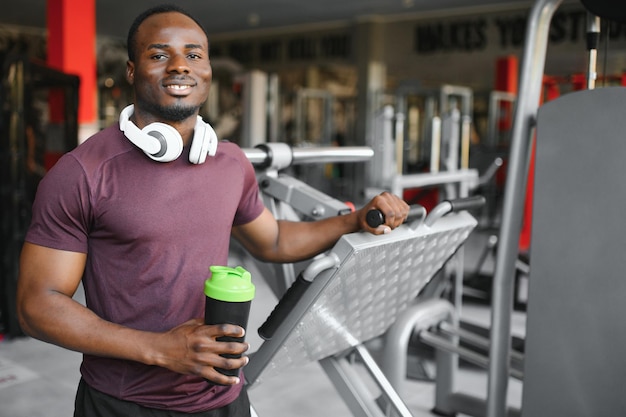 young african american sportsman drinking water in gym