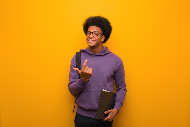 Young african american student man inviting to come