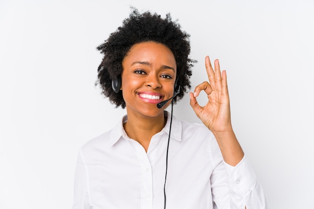 Young african american telemarketer woman isolated cheerful and confident showing ok gesture.