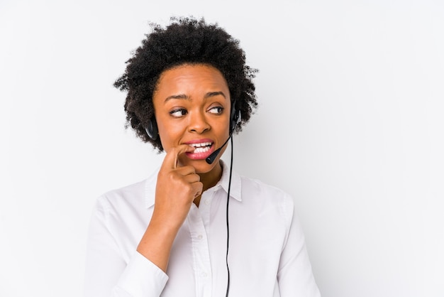 Young african american telemarketer woman isolated relaxed thinking about something looking at a copy space.