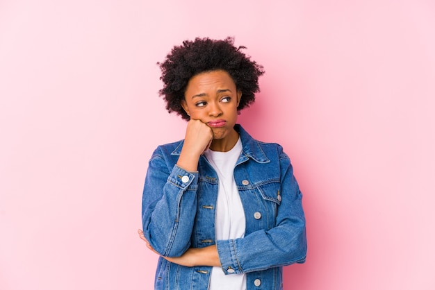 Young african american woman against a pink backgroound isolated who is bored, fatigued and need a relax day.