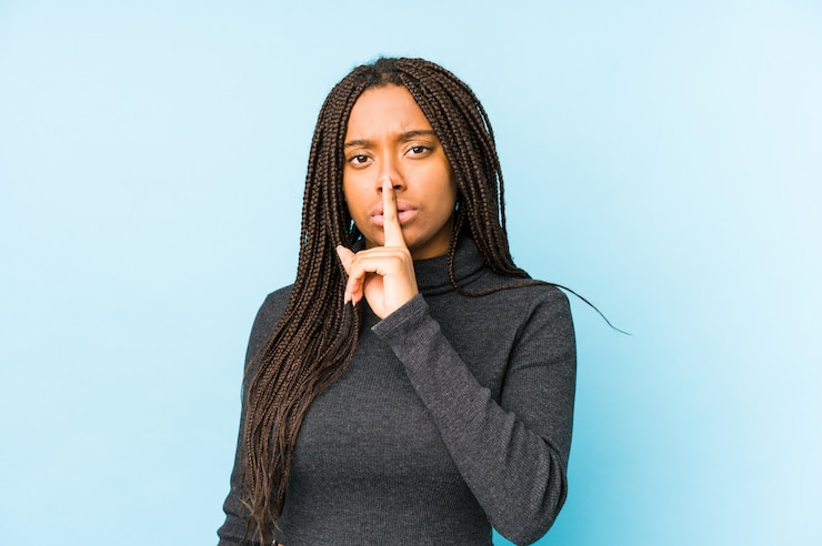 Photo young african american woman on blue wall keeping a secret