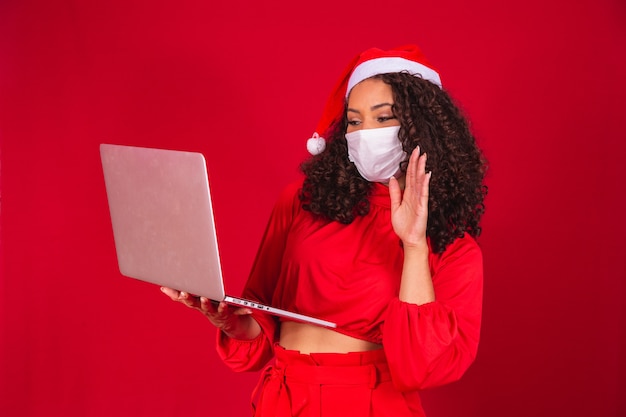 Young African-American woman celebrating Christmas at home due to coronavirus epidemic