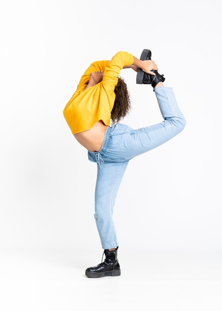 Young African American woman dancing over white wall