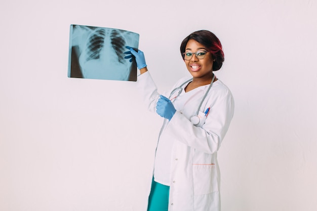 Young African American woman doctor in medical wear looking at x-ray image